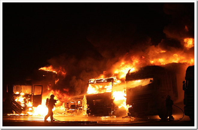 Los bomberos intentan apagar varios camiones quemados - El País